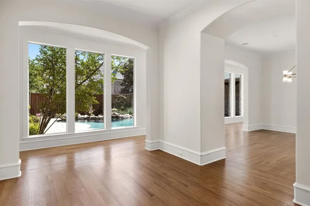 a view of a big room with wooden floor garden view and windows