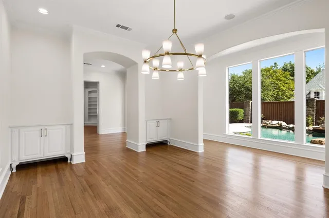 a view of a room with wooden floor fireplace and windows
