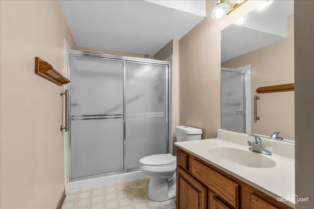 a bathroom with a sink toilet vanity and shower