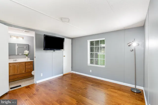 a view of a livingroom with wooden floor and a flat screen tv