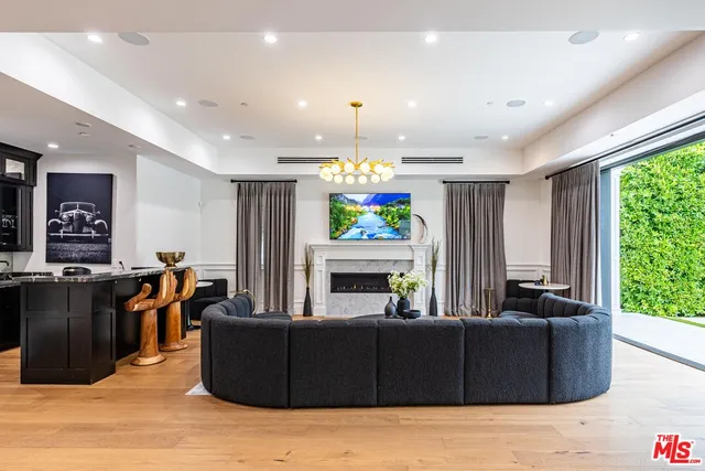 a living room with furniture a fireplace and a chandelier