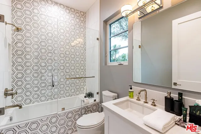 a view of a white house with a swimming pool lawn chairs and a fire pit