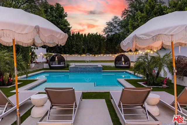 a view of a patio with couches and a table and chairs with wooden floor and fence