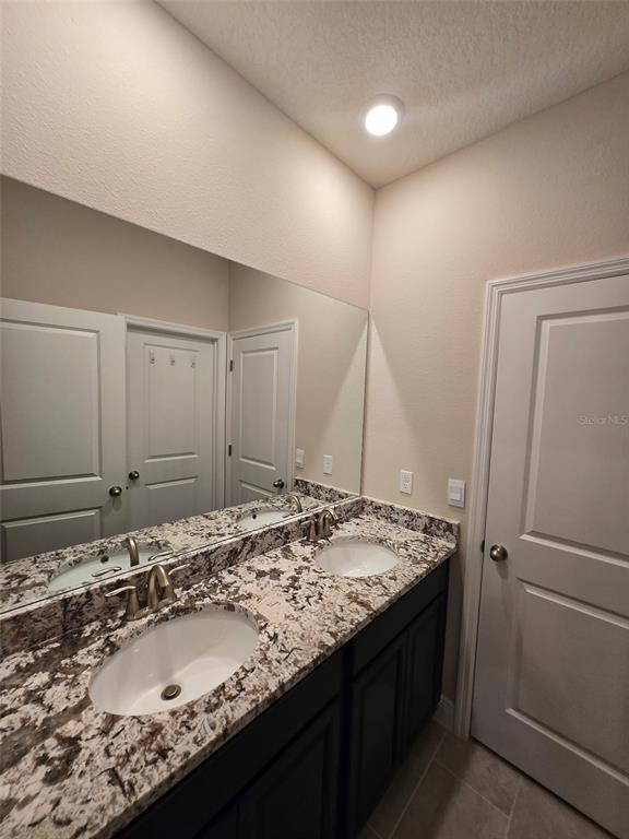 6008 Southwest 46th Drive Gainesville, FL 32608 - Photo 30 of 56 a bathroom with a granite countertop sink and a mirror