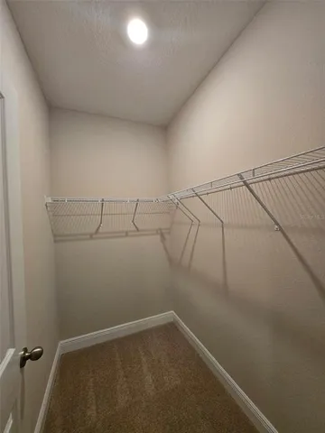 an empty room with a window and a ceiling fan