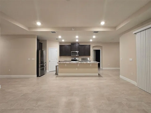 a view of kitchen with microwave and refrigerator