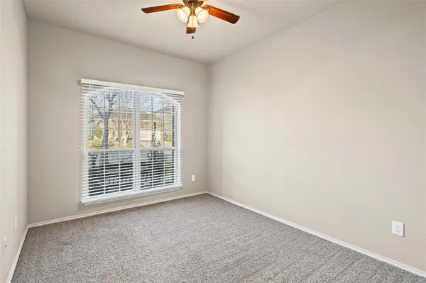 an empty room with chandelier fan
