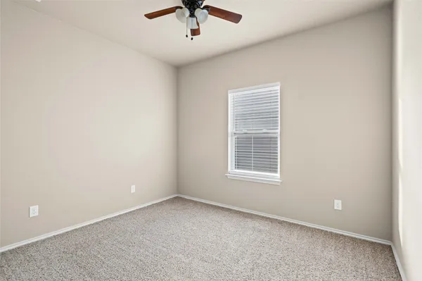 an empty room with a window and a ceiling fan