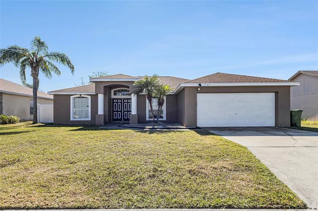 a front view of a house with yard and garage