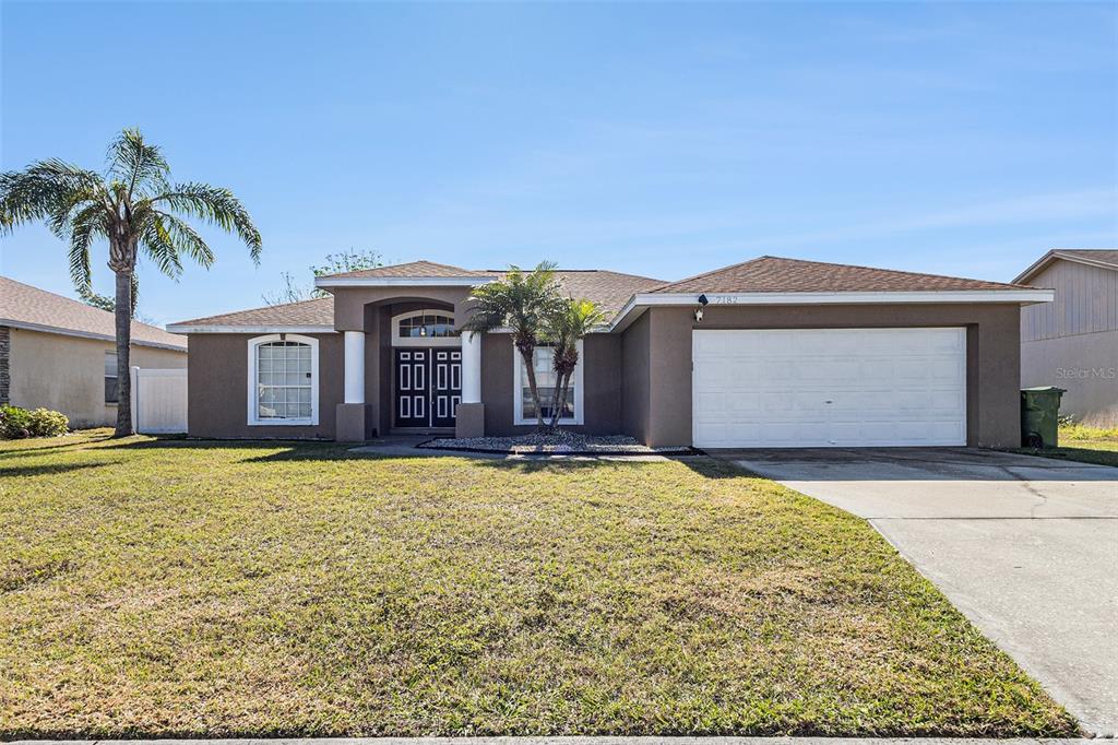 a front view of a house with yard and garage