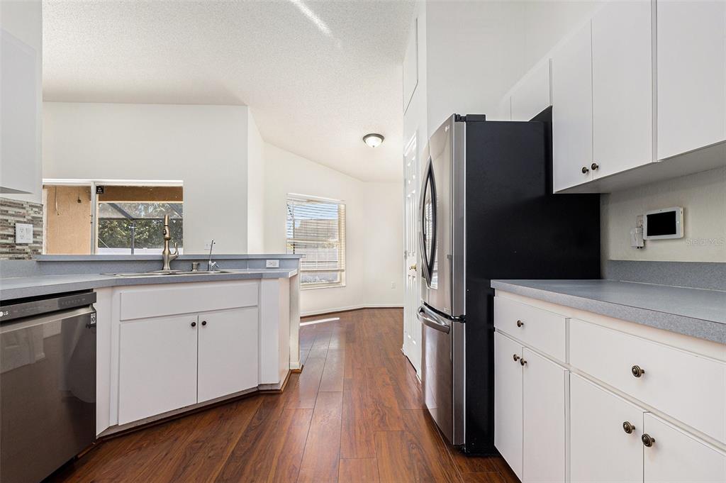 7182 Summit Drive Winter Haven, FL 33884 - Photo 11 of 27 a kitchen with stainless steel appliances a refrigerator sink and cabinets