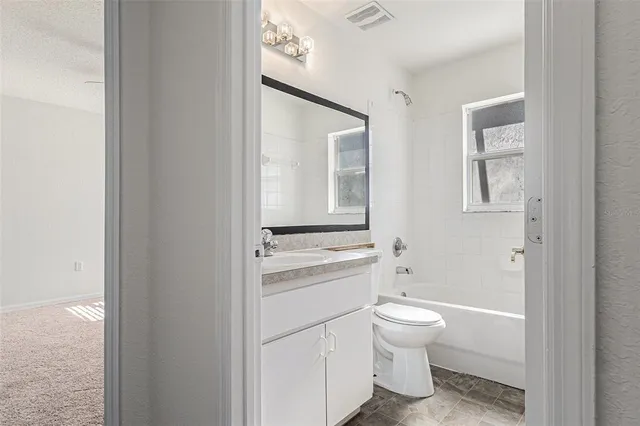 a bathroom with a granite countertop toilet a sink and a mirror