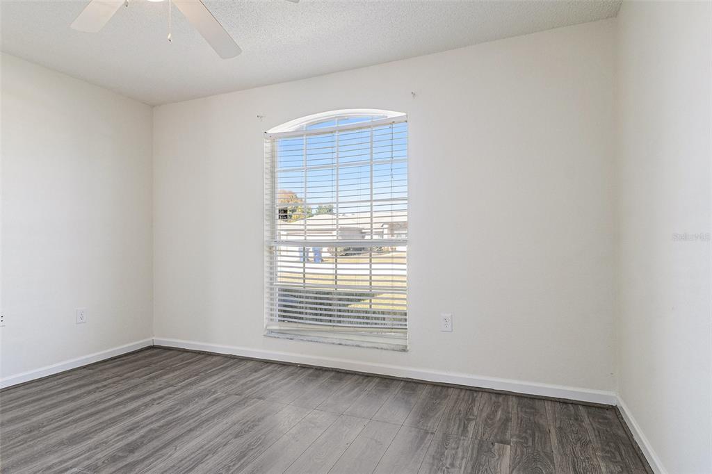 7182 Summit Drive Winter Haven, FL 33884 - Photo 22 of 27 an empty room with wooden floor and windows