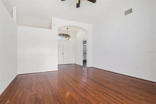 a view of an empty room with wooden floor