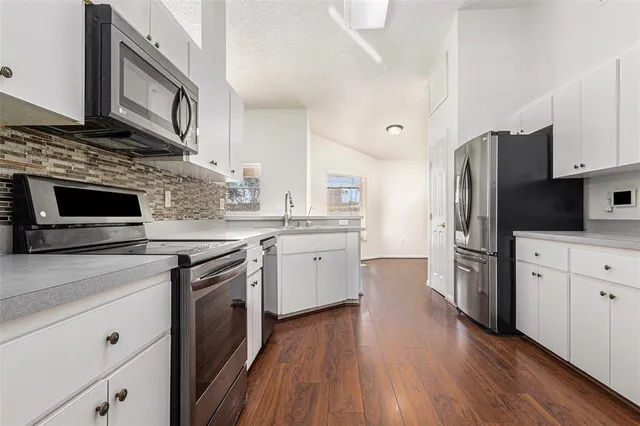 a kitchen with stainless steel appliances a stove microwave and a refrigerator