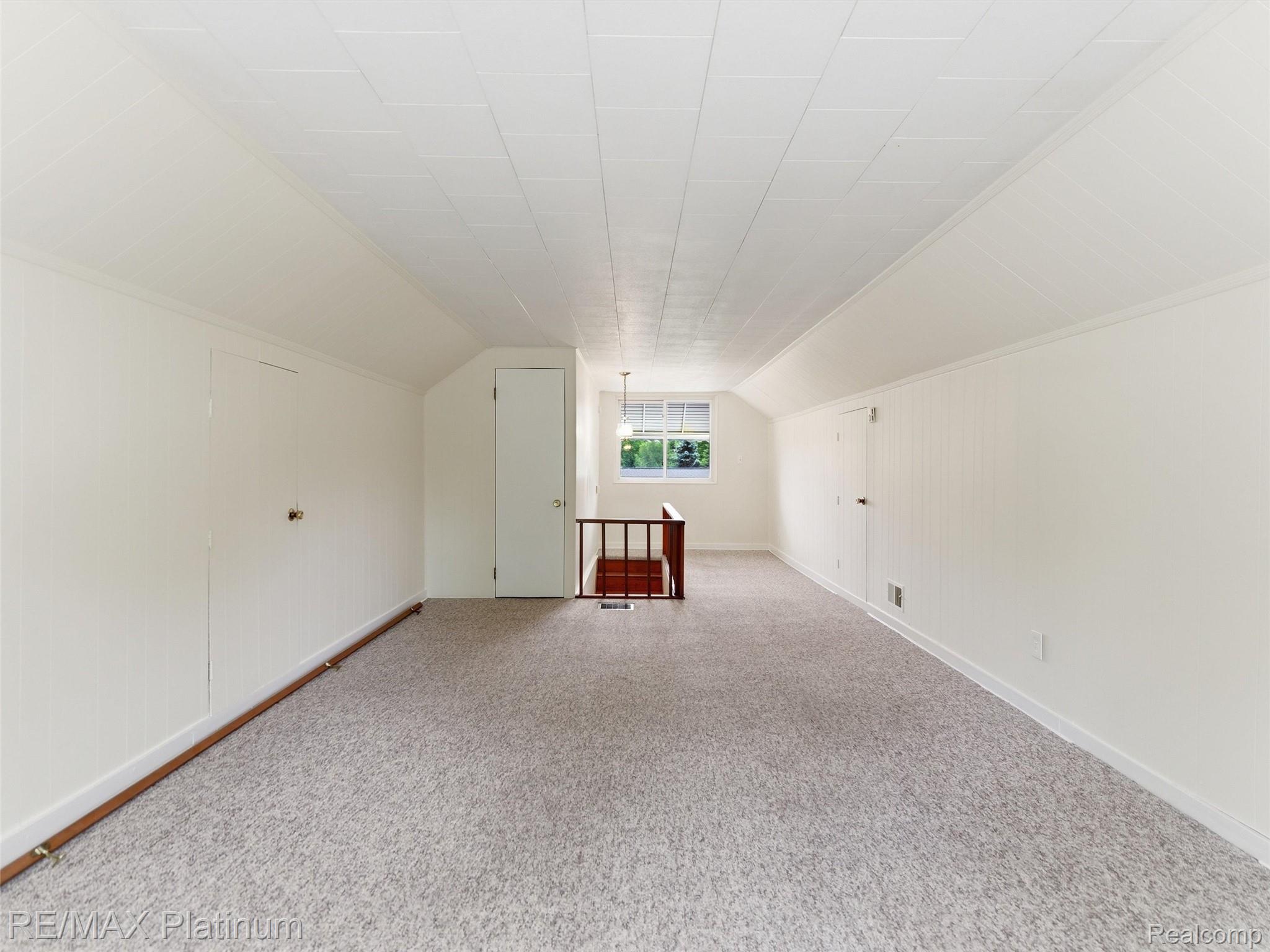 6335 Silver Lake Road Linden, MI 48451 - Photo 27 of 61 Carpeted attic space featuring white paneling, a single window, and multiple storage access doors