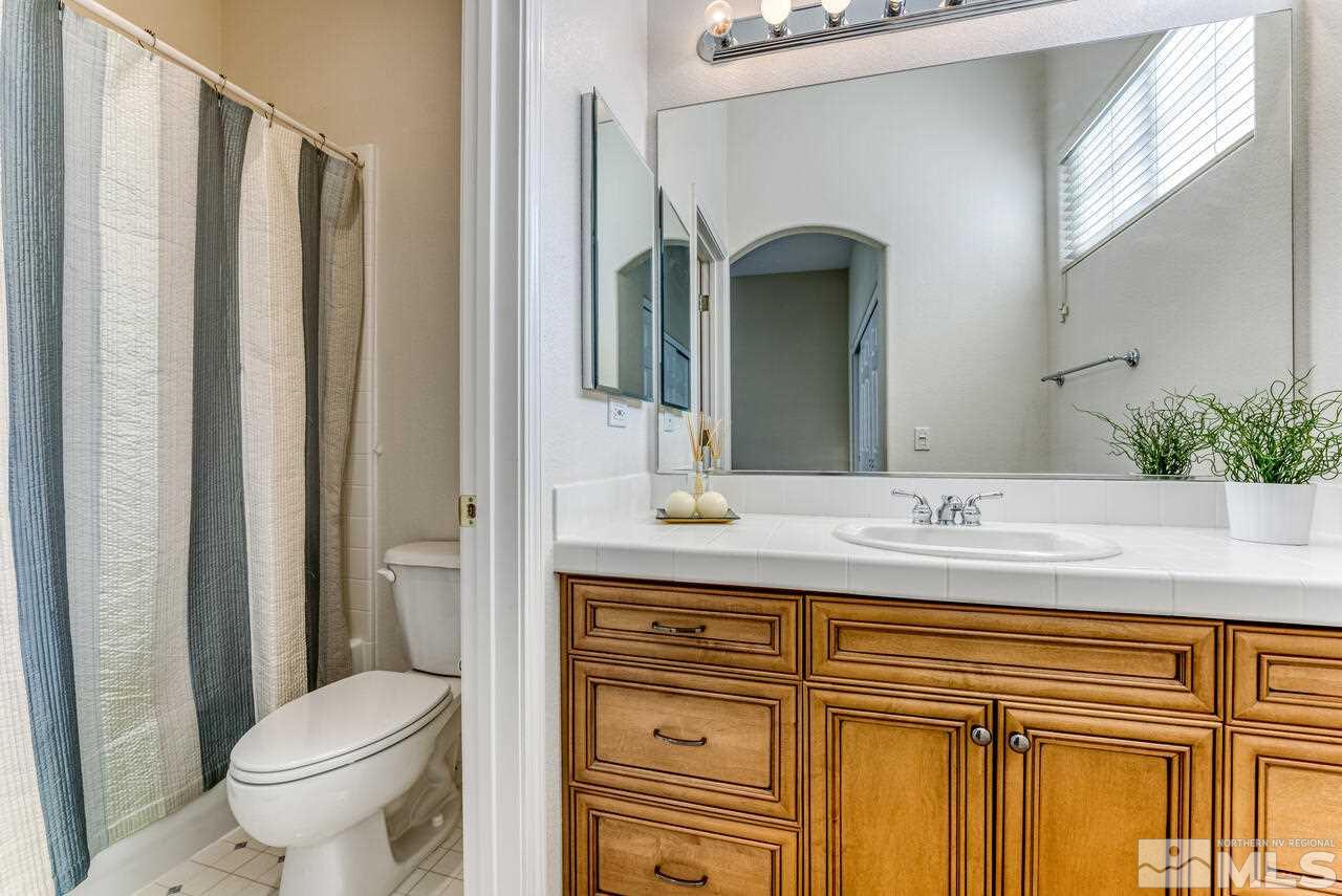 3755 Bridge Creek Court Reno, NV 89519 - Photo 23 of 40 a bathroom with a granite countertop toilet sink and mirror