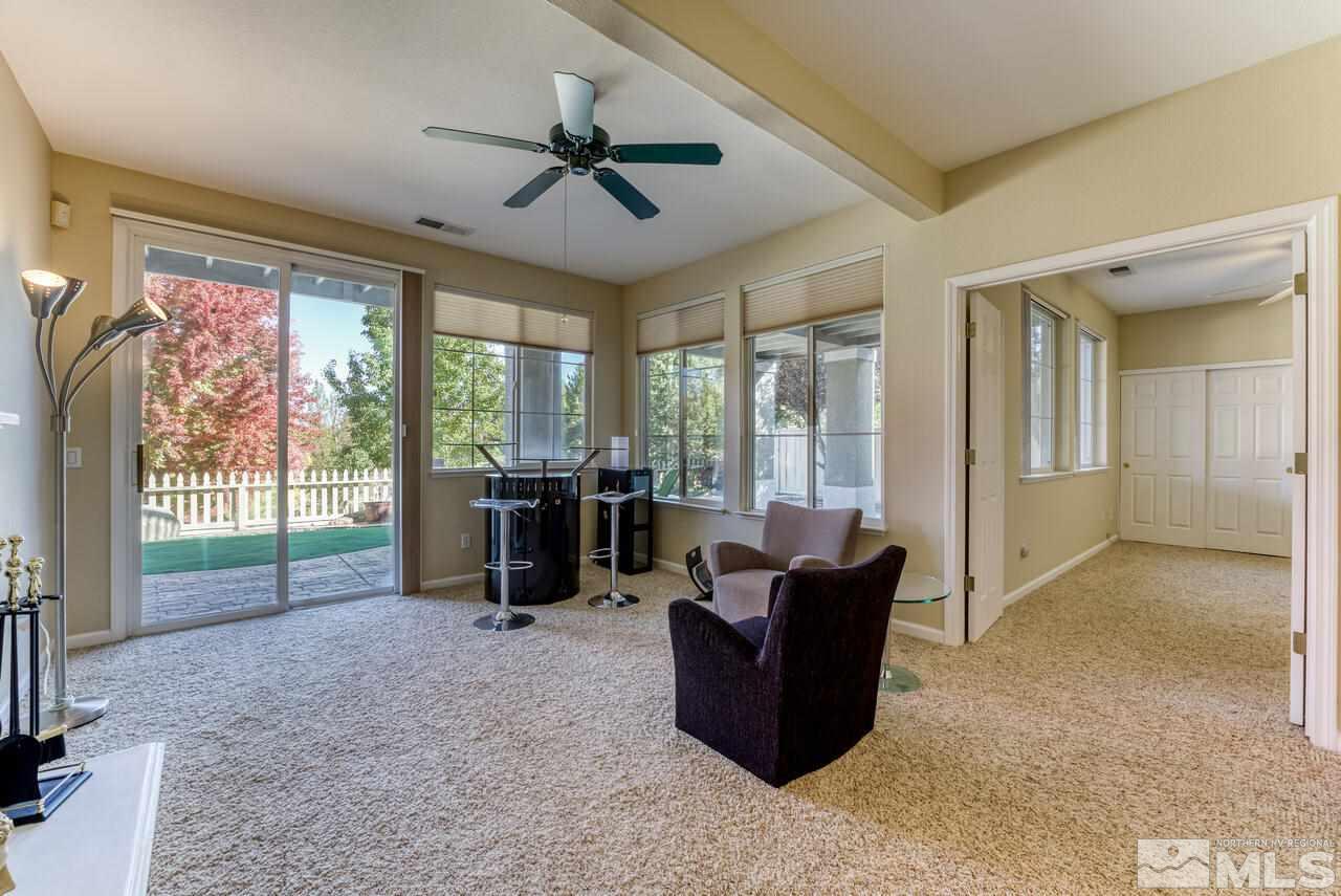 3755 Bridge Creek Court Reno, NV 89519 - Photo 24 of 40 a living room with furniture floor to ceiling window and a flat screen tv