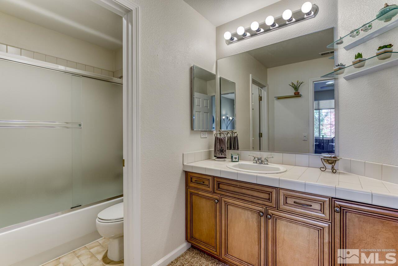 3755 Bridge Creek Court Reno, NV 89519 - Photo 32 of 40 a bathroom with a sink a toilet a mirror and shower