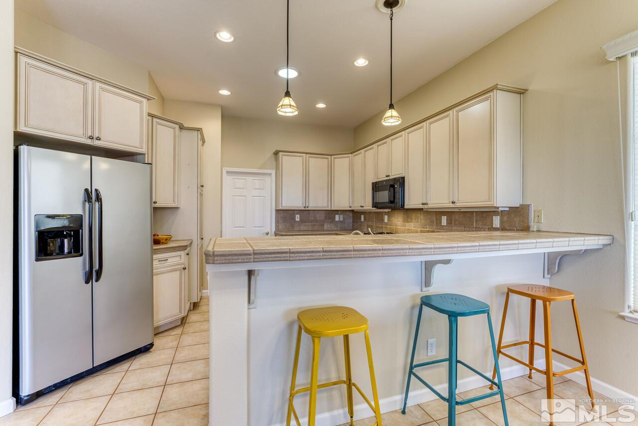 3755 Bridge Creek Court Reno, NV 89519 - Photo 5 of 40 a kitchen with stainless steel appliances granite countertop a refrigerator a sink and a stove