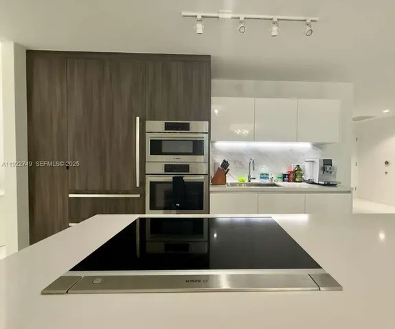 a kitchen with a sink a stove and cabinets