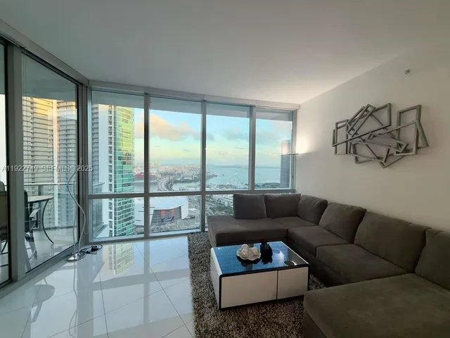 a living room with furniture and a floor to ceiling window