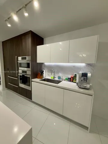 a kitchen with stainless steel appliances a sink and a refrigerator