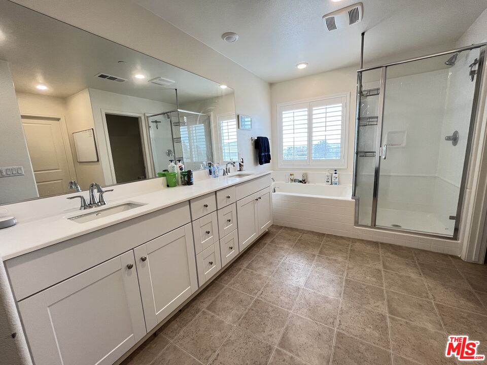 11785 Connell Road Riverside, CA 92505 - Photo 23 of 39 a large bathroom with a double vanity sink a large mirror and a shower