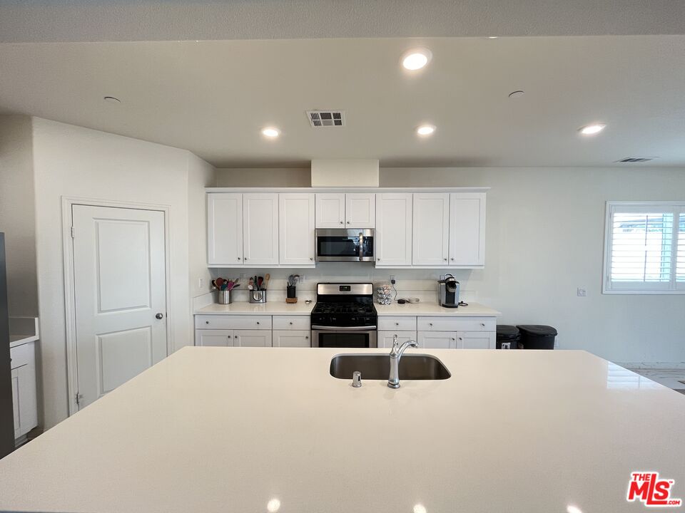 11785 Connell Road Riverside, CA 92505 - Photo 6 of 39 a living room with stainless steel appliances kitchen island granite countertop a stove and a refrigerator