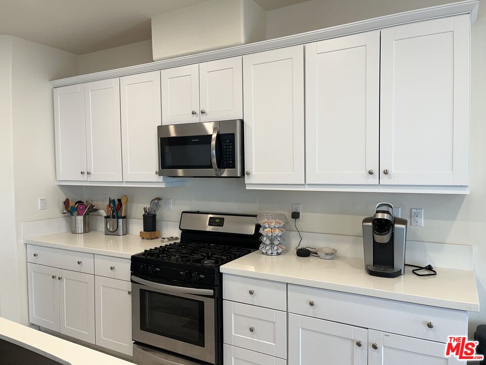 11785 Connell Road Riverside, CA 92505 - Photo 8 of 39 a kitchen with granite countertop white cabinets and stainless steel appliances