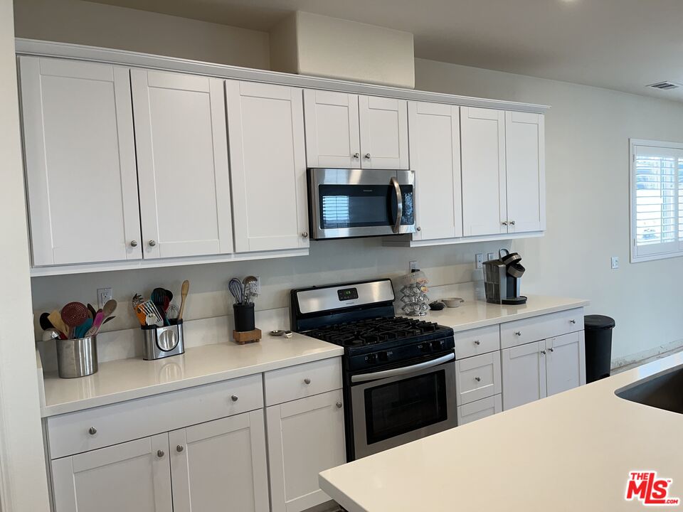 11785 Connell Road Riverside, CA 92505 - Photo 9 of 39 a kitchen with white cabinets and sink