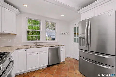 a kitchen with a refrigerator sink and window