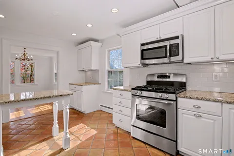 a kitchen with white cabinets a sink and white appliances