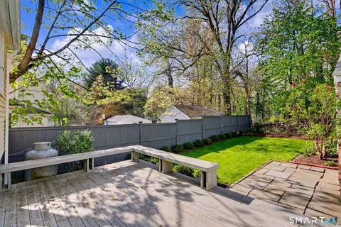a view of a backyard with a wooden fence and a bench
