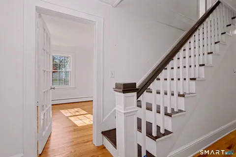 a view of staircase with wooden floor and fan