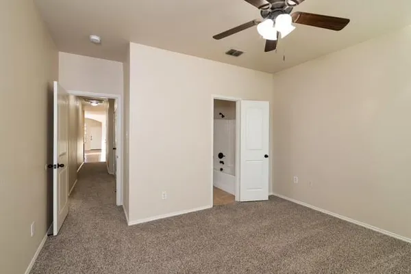 an empty room and chandelier fan in hallway