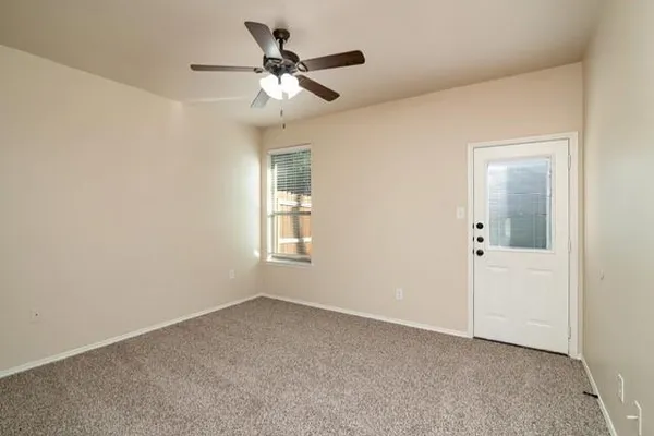 an empty room with a window and a fan