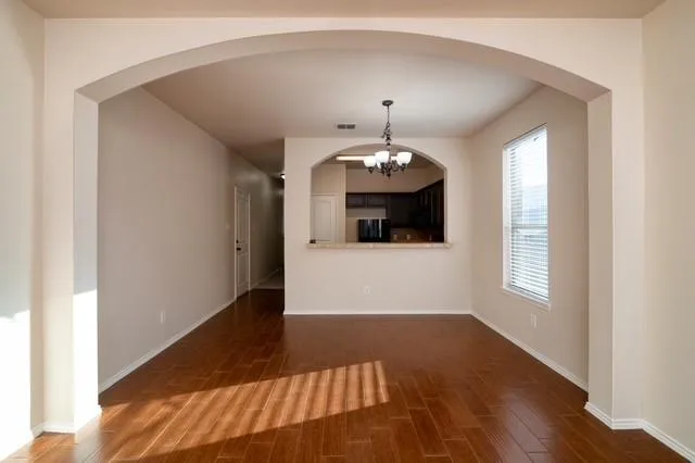 a view of a livingroom with wooden floor and chandelier
