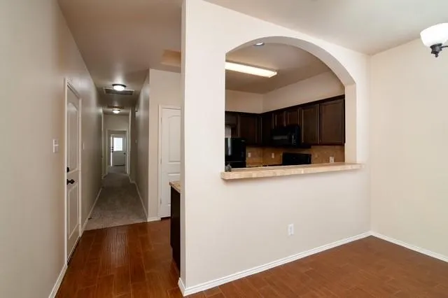 a view of a hallway with wooden floor