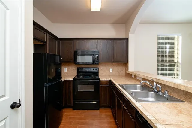 a kitchen with a sink stove and refrigerator