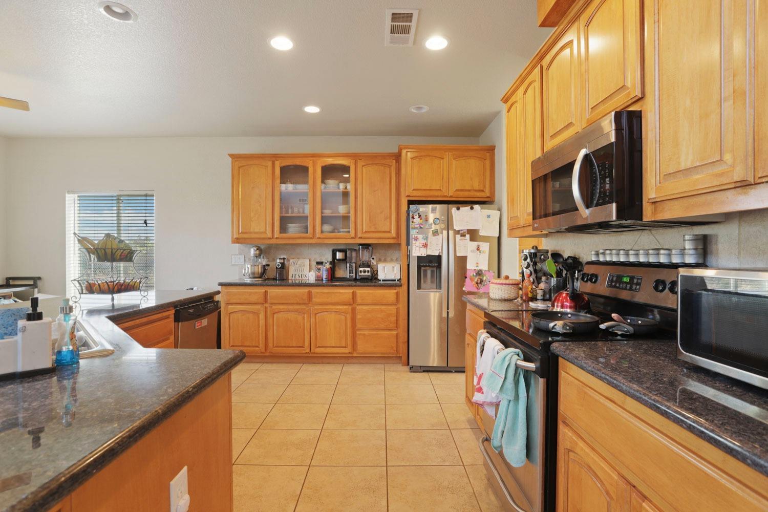 16160 Moore Road Lodi, CA 95242 - Photo 4 of 38 a kitchen with stainless steel appliances granite countertop a sink a stove and a refrigerator
