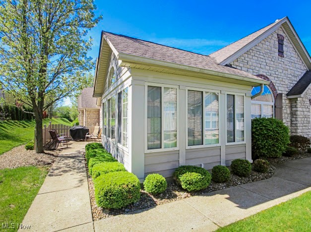9151 Springfield Road, Unit 703 Youngstown, OH 44514 - Photo 2 of 19 View of home's exterior with a shingled roof and a patio area