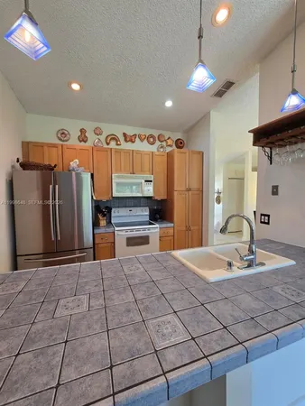 a kitchen with stainless steel appliances a refrigerator and a stove top oven