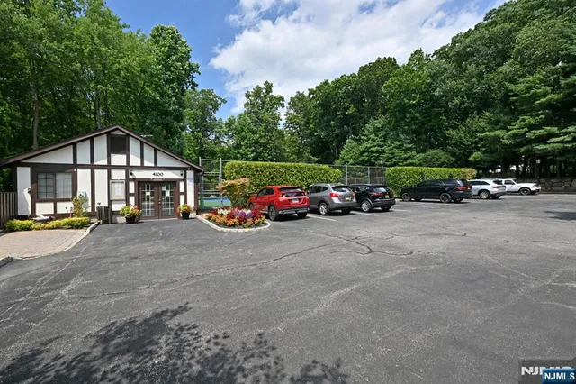a car parked in front of a house with cars parked