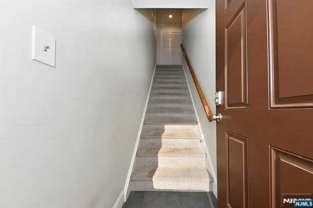 a view of staircase with white walls and white door