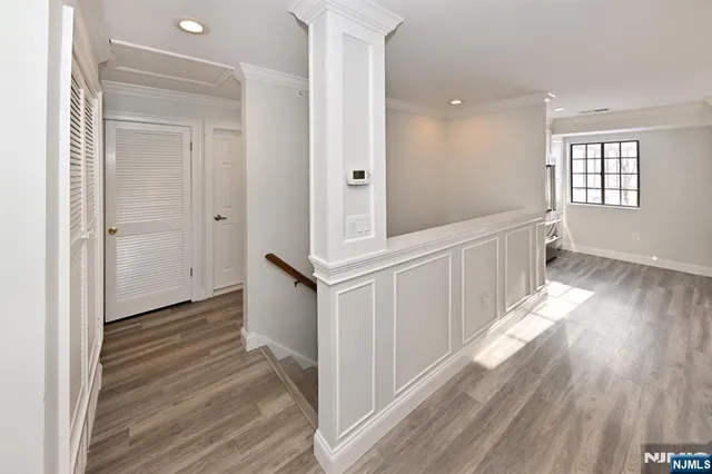 a view of a hallway with wooden floor and staircase