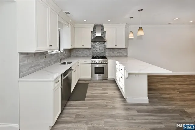 a large kitchen with cabinets appliances and wooden floor