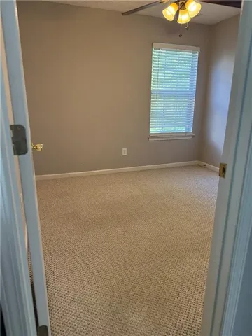 a view of an empty room with a chandelier fan