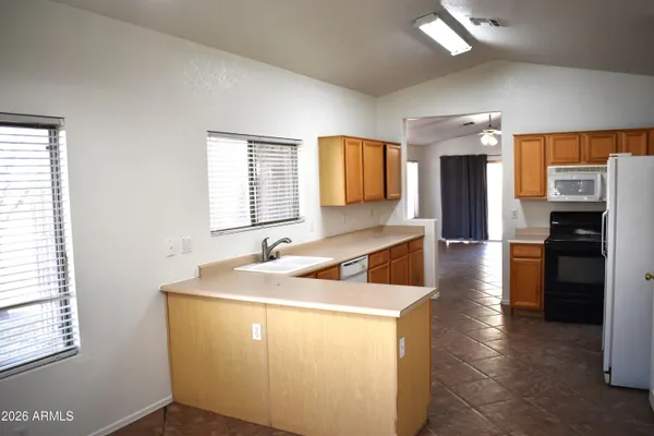 a kitchen with stainless steel appliances granite countertop a sink a stove and a refrigerator