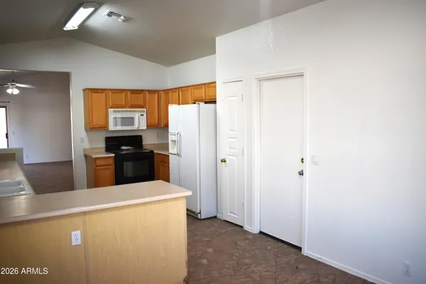 a kitchen with a refrigerator and a stove top oven